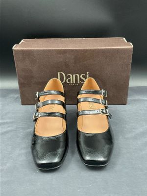 une paire de chaussures noires à boucles et une boîte