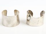 deux bracelets manchette en argent sur fond blanc