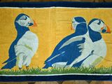 deux oiseaux posés sur un tapis posé à même le sol
