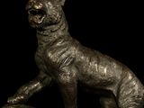 bronze statue of a dog sitting on a log