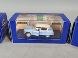 three boxed blue toy cars sitting on top of a table