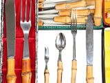 many different types of knives and forks in a box
