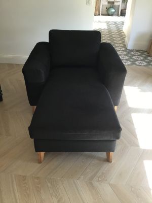 a black chair and ottoman in a living room