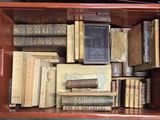 une boîte rouge remplie de vieux livres posée sur une table