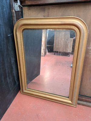 un miroir posé sur le sol à côté d'un mur