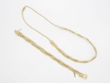 une paire de colliers en or sur fond blanc