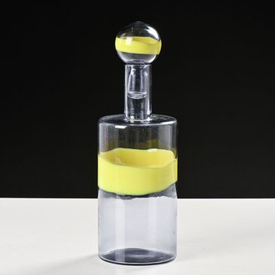 une bouteille en verre contenant un citron, posée sur une table