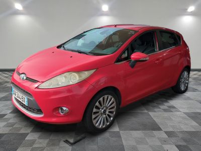 a red ford fiesta parked on a checkered floor in a garage