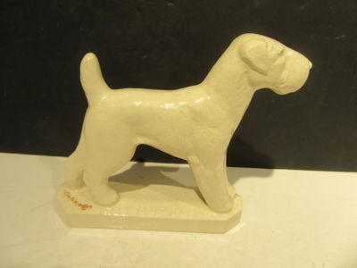 une petite statue de chien blanc posée sur une table blanche