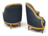 a pair of blue upholstered chairs with gold trim