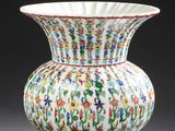 un vase blanc orné de fleurs colorées, posé sur une table