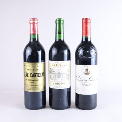 trois bouteilles de vin posées les unes à côté des autres sur une surface blanche