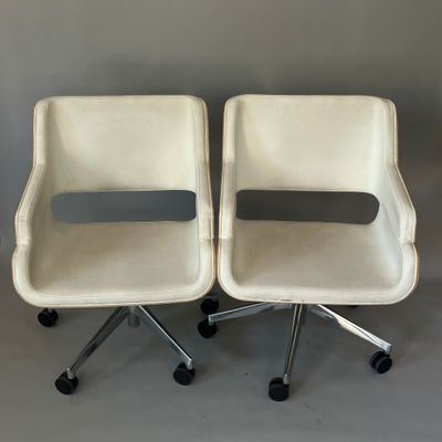 une paire de chaises blanches à roulettes sur fond gris