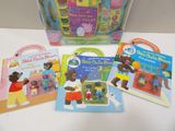 several children ' s books are sitting on a table next to a bag