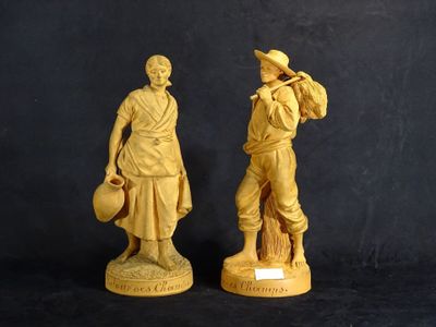 deux statues représentant un homme et une femme, avec un chapeau et un sac