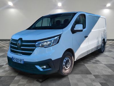 une camionnette blanche garée dans une pièce au sol en damier