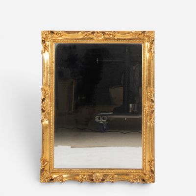 a mirror that is sitting on the floor in front of a white wall
