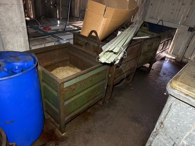 deux poubelles et un fût bleu dans une pièce