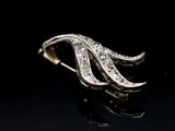 a close up of a diamond broochle on a black surface