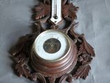 une horloge accrochée au mur, décorée de feuilles