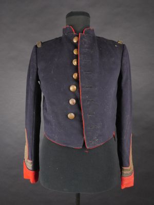 une veste bleue avec des bordures et des boutons rouges, posée sur un mannequin