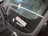 a sticker on the windshield of a car that is parked on the street