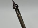 a close up of a pen with a metal tip on a white surface