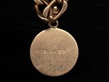 a close up of a gold chain with a coin on it