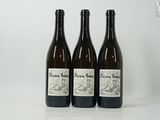 trois bouteilles de vin posées sur une table l'une à côté de l'autre