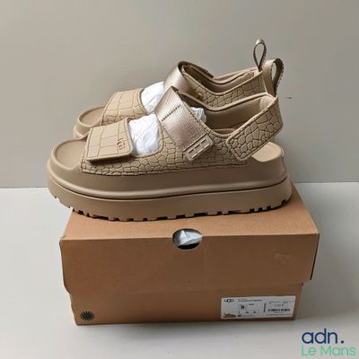 La sandale pour bébé se trouve sur la boîte posée sur la table.