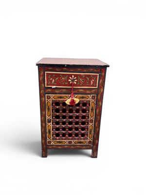 an image of a small wooden cabinet with a red and gold design
