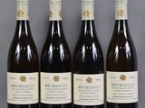 four bottles of wine are lined up on a table