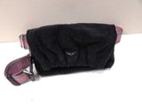 a small black bag with a pink handle on a white table
