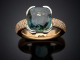 a close up of a ring with a blue diamond on a black surface