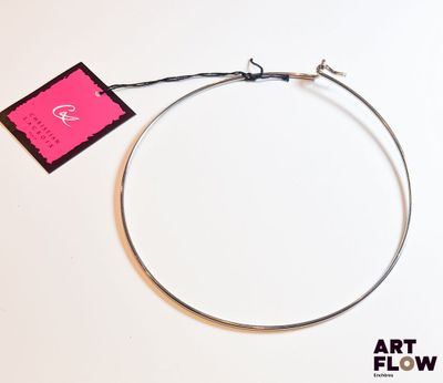 un collier en argent auquel est attachée une étiquette rose