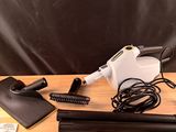 un aspirateur noir et blanc et une serviette jaune et blanche posés sur une table