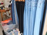 many pairs of jeans hanging on a rack in a store