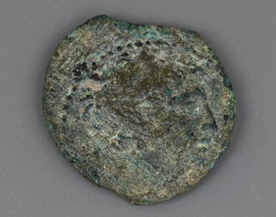 Gros plan sur une pièce de monnaie posée sur une table, sur fond gris