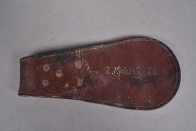 une vieille paire de chaussures marron avec une semelle en cuir sur un fond blanc