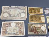 several different types of bank notes are displayed on a table