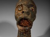 une image représentant une sculpture d'une tête avec un nid d'oiseau dans la bouche