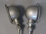 two silver lamps that are on the wall