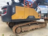 a yellow and black excavator sitting in a parking lot