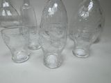 five clear glass vases sitting next to each other on a table