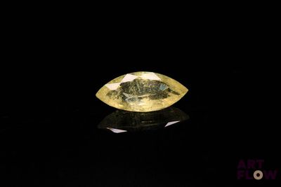 un diamant jaune sur une surface noire