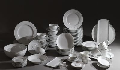 beaucoup d'assiettes et de bols blancs sur la table