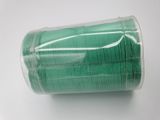 a roll of green thread on a white surface