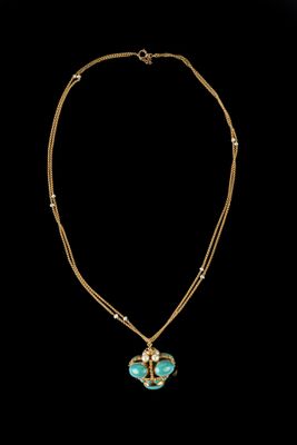 un collier en or et turquoise avec un pendentif en forme de cœur