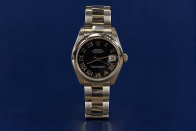 a close up of a watch on a blue surface with a blue background