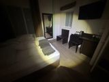 a bed and desk in a small room with a tv